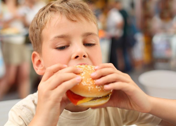 Ребенок ест гамбургер